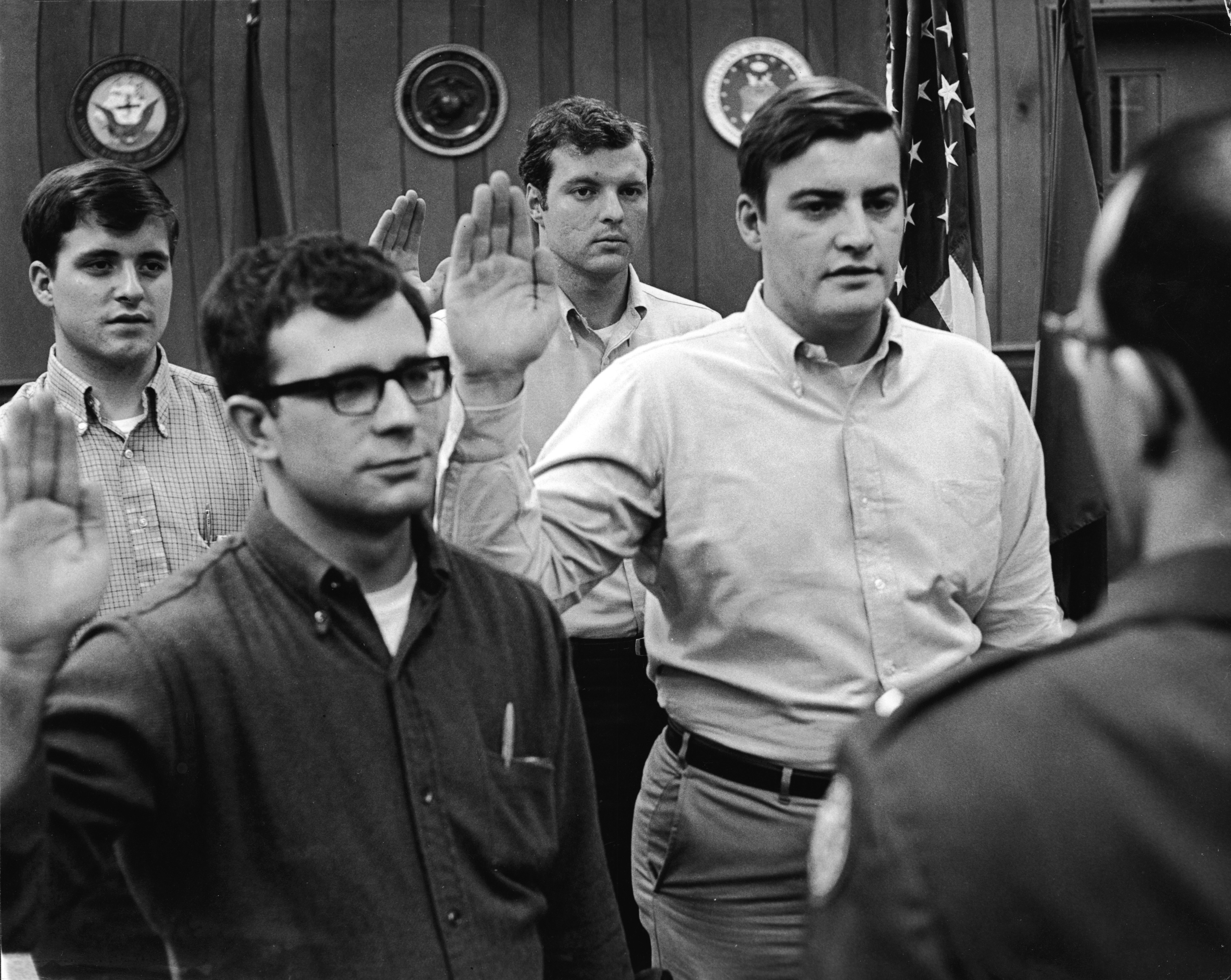 Four male civilians, with their hands raised to take an oath, stand before a military personnel man and prepare to be sworn in and become recruits in the armed forces during the Vietnam War Era, St. Paul, Minnesota, mid 1960s. (Photo by Rohn Engh/FPG/Getty Images)